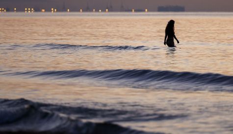 Una joven toma un baño al amanecer en la playa de la Malvarrosa de Valencia. Una joven toma un baño al amanecer en la playa de la Malvarrosa de Valencia.
