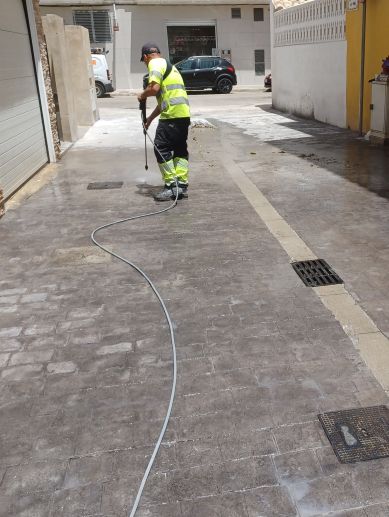 Un operario limpia el pavimento tras las obras de reposición en la calle Mola de Alfafar. / - Veolia Un operario limpia el pavimento tras las obras de reposición en la calle Mola de Alfafar. / - Veolia