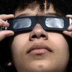 Una persona observa un eclipse parcial de sol con unas gafas especiales. / EFE/Neil Hall