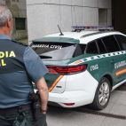Imagen de archivo de un vehículo de la Guardia Civil junto a un agente de este cuerpo. / EFE-Paco Paredes