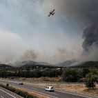 Un hidroavión sobrevuela la autovía A-7 tras realizar una descarga de agua en Betxí en el frente del incendio declarado este sábado en la Vall d'Uixó.