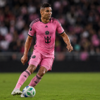 Casemiro con uniforme rosa controla el balón en el campo durante un partido.