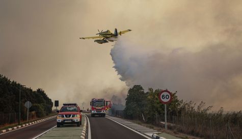 Un hidroavión realiza una descarga de agua sobre la carretera CV-500 ante el avance del incendio forestal declarado en El Saler. / EFE-Biel Aliño Un hidroavión realiza una descarga de agua sobre la carretera CV-500 ante el avance del incendio forestal declarado en El Saler. / EFE-Biel Aliño