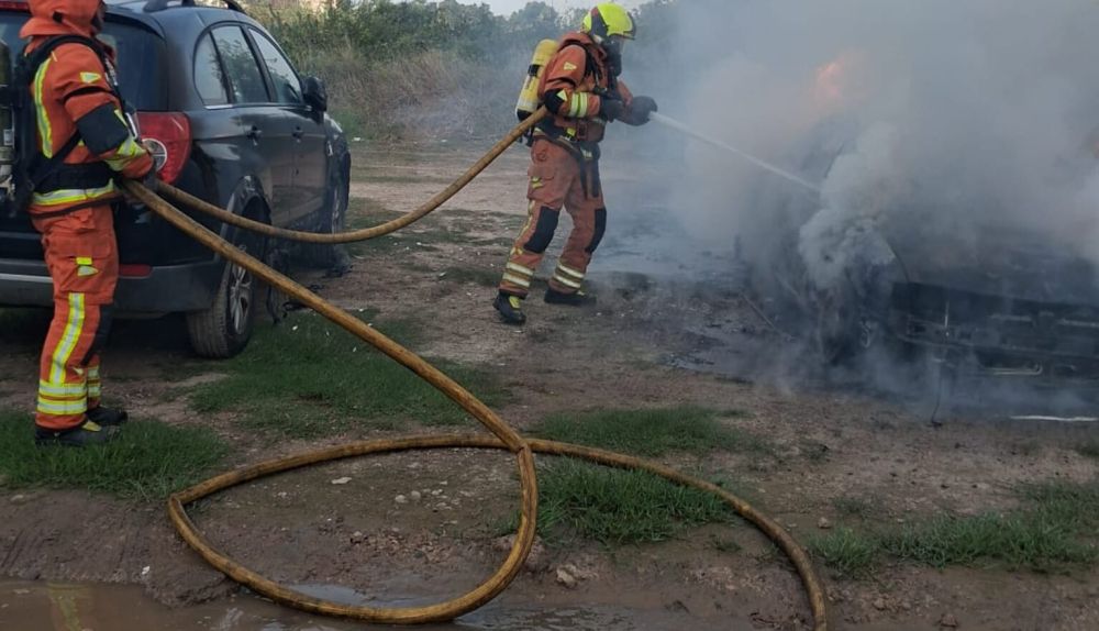 Un bombero sofoca las llamas del vehículo incendiado en el Camí Platja del Puig de Santa Maria. / Consorci Provincial de Bombers de València Un bombero sofoca las llamas del vehículo incendiado en el Camí Platja del Puig de Santa Maria. / Consorci Provincial de Bombers de València