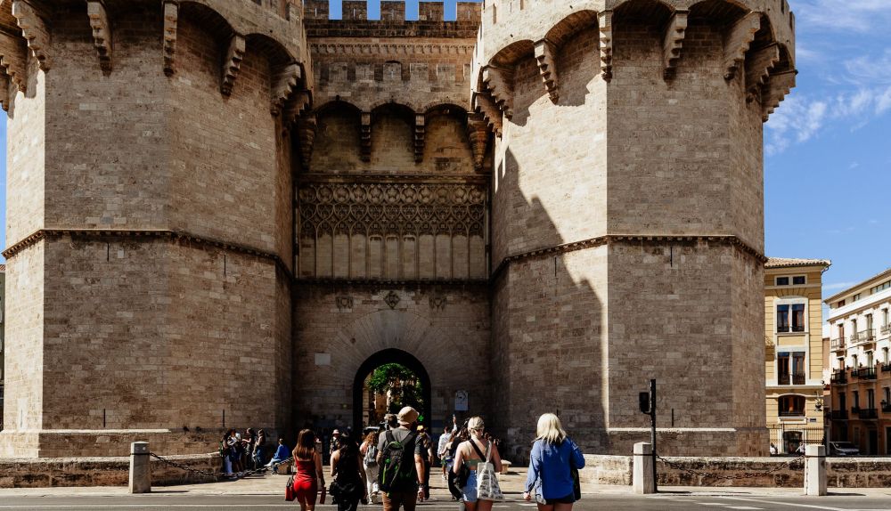 Varias personas se dirigen hacia las Torres de Serranos, la puerta monumental de la antigua muralla de Valencia. Varias personas se dirigen hacia las Torres de Serranos, la puerta monumental de la antigua muralla de Valencia.
