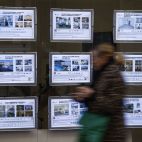 Una persona pasa ante los anuncios de venta y alquiler de vivienda en una inmobiliaria de Valencia. / EFE-Biel Aliño