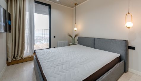 Un dormitorio con una cama de matrimonio y un colchón acolchado sobre una base tapizada en gris. / Max Vakhtbovych