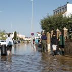 Unos vecinos cruzan una calle anegada en Oliva tras el paso de la dana Adam por la Comunitat Valenciana. / EFE-Manuel Bruque