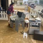 Una vecina de Oliva saca sus pertenencias a la terraza tras el paso de la dana Adam por la Comunitat Valenciana.