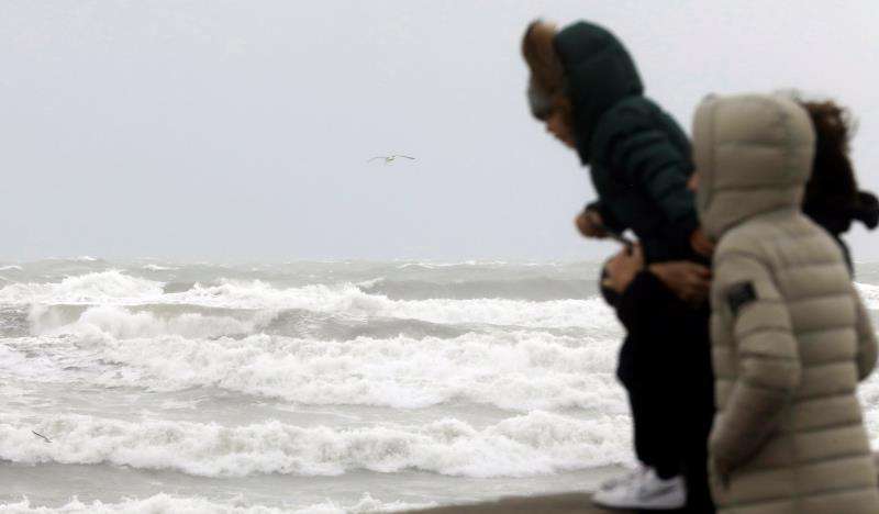 Tres personas observan el temporal marítimo en la playa de la Malvarrosa de Valencia. EFE/Archivo
