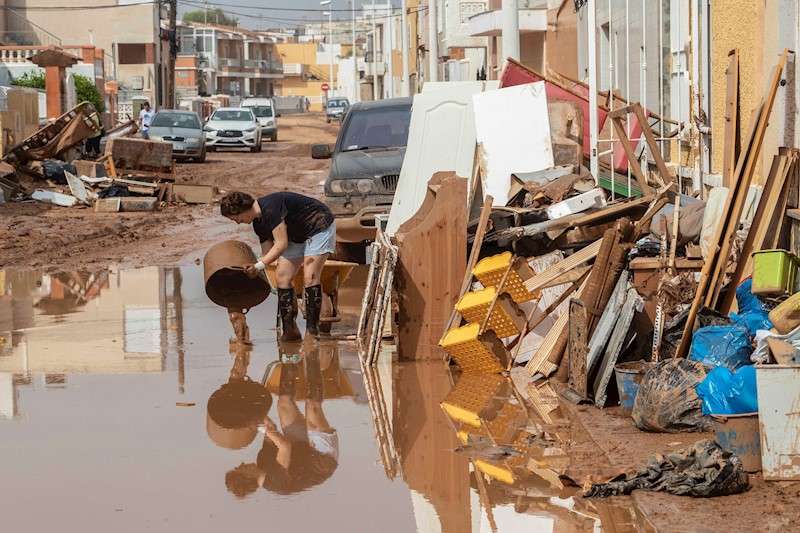 Una mujer vierte lodo en la calle en la localidad de Los Nietos, en Cartagena. EFE