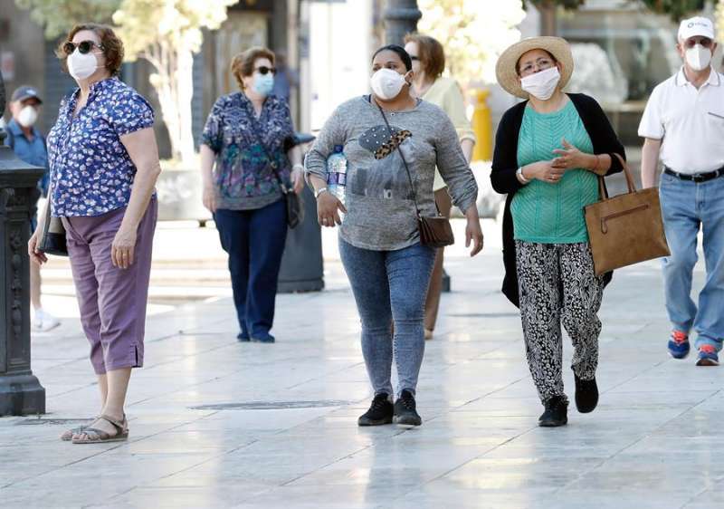 Varias personas pasean con mascarilla. EFE