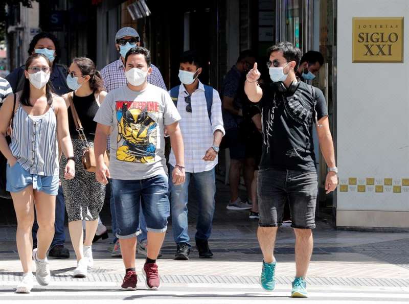 Transeúntes protegidos con mascarillas por una calle. EFE/ Juan Carlos Cárdenas