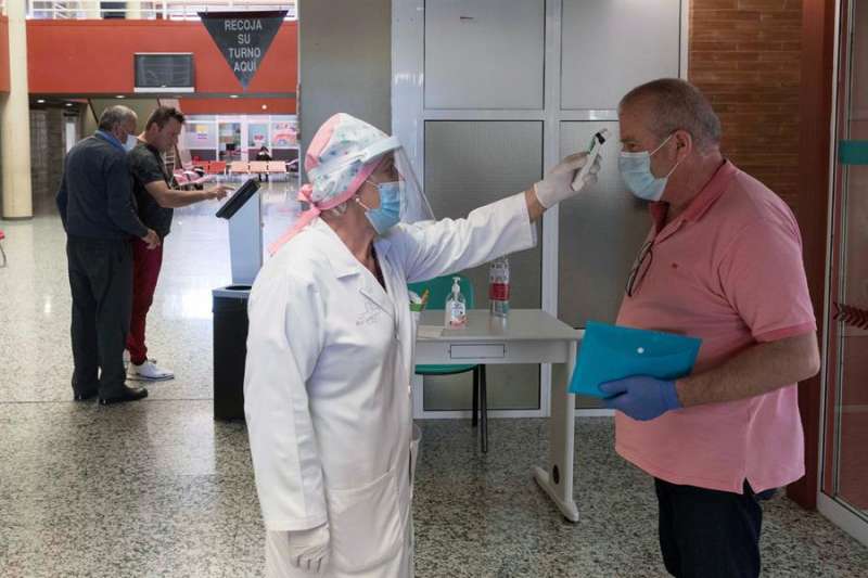 Una enfermera toma la temperatura a un paciente. E/Marcial Guillén/Archivo
