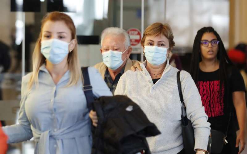 Varias personas caminan con mascarilla por las calles. EFE