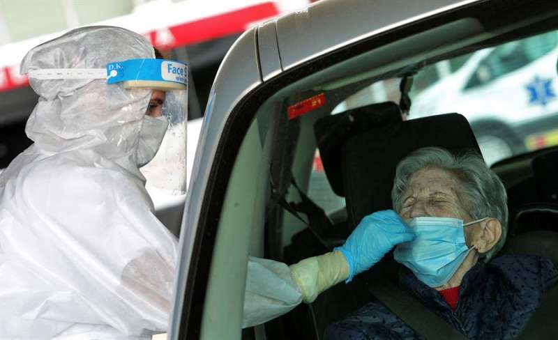 Una sanitaria protegida con EPI toma una muestra para una prueba PCR frente al hospital de Gandía. EFE/Natxo Francés/Archivo

